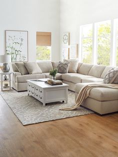 a living room filled with lots of furniture and decor on top of a hard wood floor