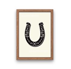 a black and white print with the letter u in it's center, hanging on a wooden frame