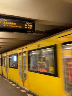 a yellow train traveling through a subway station