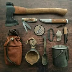 an assortment of gardening tools and other items on a wooden table with a leather pouch