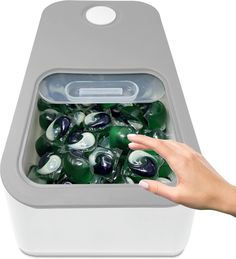 a hand reaching into an ice chest filled with green and white marbles