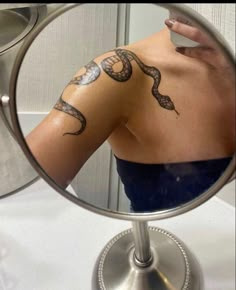 a woman's arm is shown in front of a mirror with tattoos on it