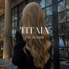 a woman with long blonde hair standing in front of a restaurant window that says tia fire, to burn