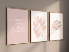 three pink and gold framed art prints on the wall