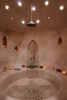 an indoor spa with candles and lights around it