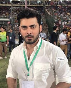 a man standing in front of a crowd at a sporting event wearing a white shirt