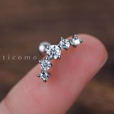 a person's finger with three small white diamonds on top of their thumb,