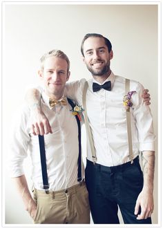 two men wearing bow ties and suspenders pose for the camera with their arms around each other