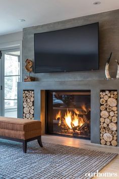 a living room with a fire place and television on the wall above it's fireplace