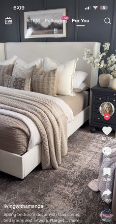 a large bed sitting in a bedroom next to a chair and table with flowers on it