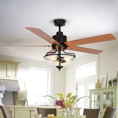 a dining room table with chairs and a ceiling fan in the middle of it,