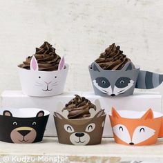 cupcakes with chocolate frosting and animal faces are on top of a box