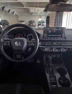 the inside of a car with dashboard, steering wheel and dash lights on display in a showroom