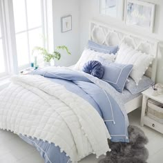 a bed with blue and white comforters in a bedroom