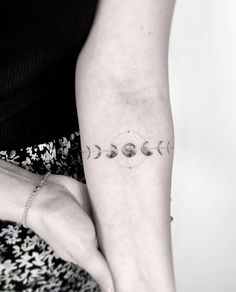 a woman's arm with five phases of the moon tattoo on her left forearm