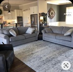 a living room with two couches and a rug on the floor in front of it