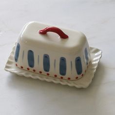 a white cake with blue and red icing on it sitting on a platter