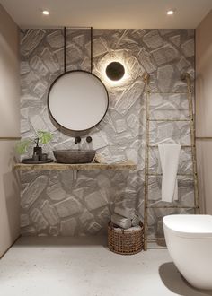 a bathroom with a round mirror above the sink and a ladder in front of it