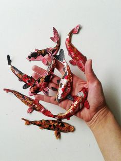 a hand is holding several miniature fish in it's palm