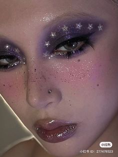 a woman with purple makeup and stars on her face