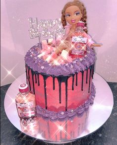 a barbie doll sitting on top of a pink and purple cake with chocolate icing