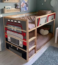 a child's bedroom with a bunk bed, desk and wall hangings on the walls