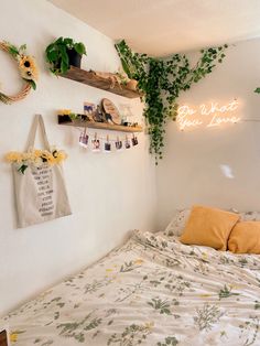 a bed sitting under a neon sign next to a wall filled with flowers and plants