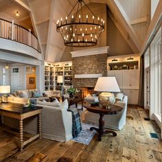 a living room filled with lots of furniture and a chandelier hanging from the ceiling