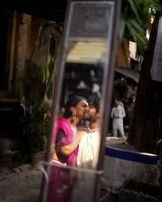 a man and woman standing in front of a mirror