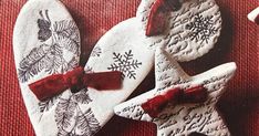 three decorated cookies with red bows and snowflakes on them are sitting on a table