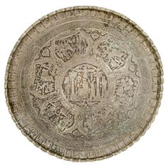 an old decorative plate with writing and symbols on the surface, isolated against a white background