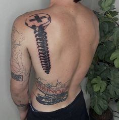 a man with a tattoo on his back has a screw in the shape of a wrench