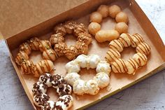 a box filled with different types of doughnuts on top of a white table