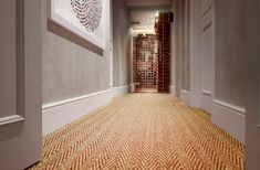 the hallway is lined with wine bottles and carpeted flooring that matches the walls