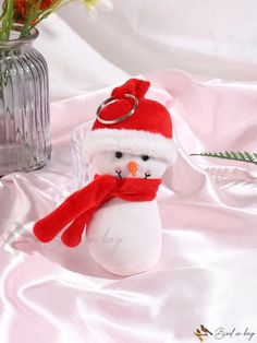 a snowman keychain with a red hat and scarf around it's neck