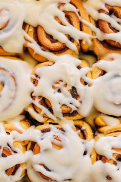 cinnamon rolls with white icing on top are arranged in a square pattern and stacked together