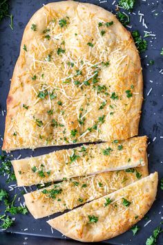 an uncooked pizza with parmesan cheese and herbs on the top, cut into four slices