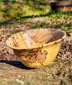 a wooden bowl sitting on top of a tree stump