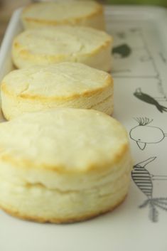 four biscuits sitting on top of a cutting board