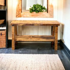 a wooden bench sitting in front of a mirror next to a shelf with baskets on it