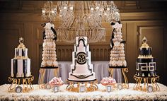 a table topped with lots of cakes and desserts next to a chandelier