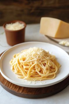 a white plate topped with spaghetti and cheese