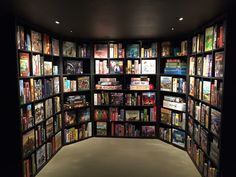 a large book shelf filled with lots of books next to a wall full of books