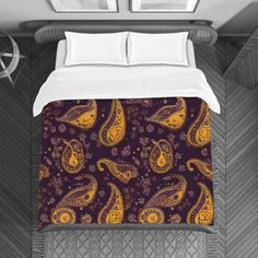 a bed covered in a purple and yellow comforter