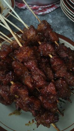 several skewers of meat sitting on top of a plate