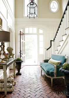 a living room filled with furniture next to a stair case and a lamp on top of a table