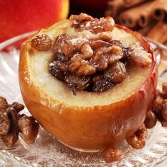 an apple filled with nuts on top of a glass plate