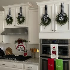 a kitchen with white cabinets and christmas decorations