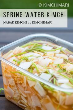 spring water kimchi in a plastic container on a wooden table