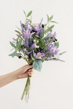 a person holding a bouquet of flowers in their hand